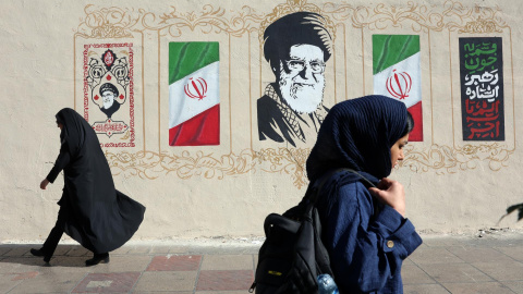 Mujeres iraníes caminan junto a un mural del difunto Líder Supremo iraní, el ayatolá Ali Jamenei, en una calle de Teherán, Irán. Mujeres iraníes caminan junto a un mural del difunto Líder Supremo iraní, el ayatolá Ali Jamenei, en una calle de Teherán, Irán.