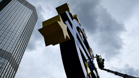 Un trabajador limpia la escultura con el símbolo del euro frente a la sede del Banco Central Europeo. Un trabajador limpia la escultura con el símbolo del euro frente a la sede del Banco Central Europeo.