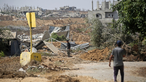 AFP__20260722__C2UM7MH__v1__MidRes__PalestinianIsraelConflictGaza Palestinos pasan junto a un bloque de concreto que marca la «Línea Amarilla» trazada por el ejército israelí al este de Deir al-Balah, en el centro de la Franja de Gaza, el 22 de julio de 2026