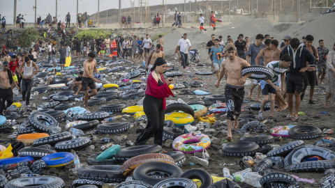 Flotadores y jóvenes migrantes en la playa este viernes en Ceuta junto a la frontera con Marruecos. Flotadores y jóvenes migrantes en la playa este viernes en Ceuta junto a la frontera con Marruecos.