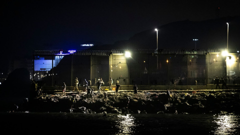 Personas llegan a la orilla del Tarajal tras cruzar a nado la frontera marítima. Personas llegan a la orilla del Tarajal tras cruzar a nado la frontera marítima.