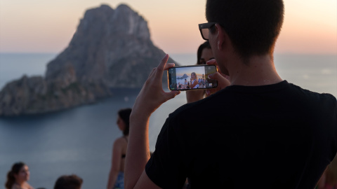 EuropaPress_4623036_joven_hace_fotografia_atardecer_cala_dhort_agosto_2022_ibiza_baleares Un joven hace una fotografía del atardecer en la Cala d'Hort, a 7 de agosto de 2022, en Ibiza, Baleares (España).
