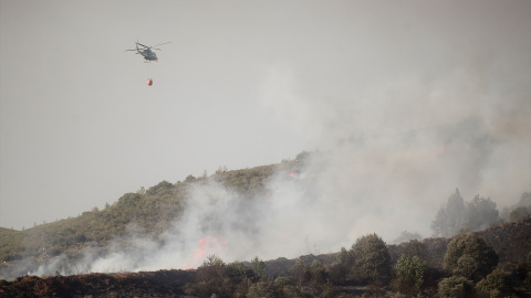 Un helicóptero durante las labores de extinción de un incendio forestal. Un helicóptero durante las labores de extinción de un incendio forestal.