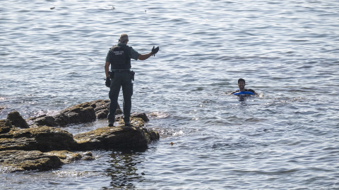 Un guardia civil junto a una persona en el mar, a 2 de agosto de 2026, en la frontera de Ceuta. Un guardia civil junto a una persona en el mar, a 2 de agosto de 2026, en la frontera de Ceuta.