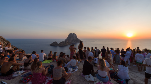Decenas de personas disfrutan del atardecer en la Cala d'Hort.
