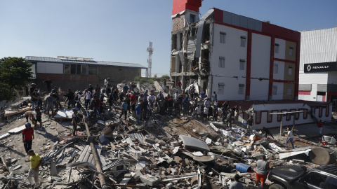 Personas caminan sobre los escombros de un edificio colapsado tras el terremoto, en la ciudad colombiana de Cali. Personas caminan sobre los escombros de un edificio colapsado tras el terremoto, en la ciudad colombiana de Cali.