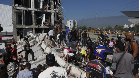 Personas caminan sobre los escombros de un edificio colapsado en Cali (Colombia). Personas caminan sobre los escombros de un edificio colapsado en Cali (Colombia).