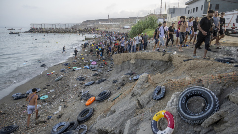 Decenas de migrantes tras haber traspasado la frontera entre Ceuta y Marruecos, a 31 de julio de 2026.