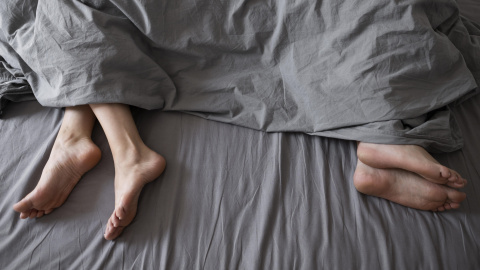Dos personas separadas en una cama. Dos personas separadas en una cama.