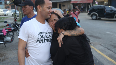 AME9171. GUATIRE (VENEZUELA), 14/08/2026.- Merwin Vázquez (i) abraza a sus familiares tras ser excarcelado del centro penitenciario Rodeo 1 este viernes, en Guatire (Venezuela). Al menos 40 presos políticos fueron excarcelados, informó la ONG Foro Penal, líder en la defensa legal de estos detenidos, un hecho que se da dos días después de haber culminado la primera ronda de negociaciones entre el chavismo y un sector de la oposición liderado por la exdiputada Dinorah Figuera. EFE/ Ronald Peña R