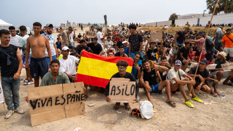 Migrantes protesta Ceuta Un grupo de migrantes concentrados para solicitar asilo este domingo en la playa del trampolín de Ceuta. EFE/ Reduan