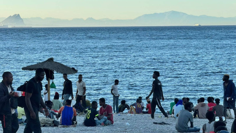 Varios migrantes en la playa del Trampolín.