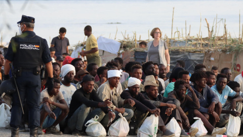 Personas migrantes aguardando en la Playa del Trampolín para ser trasladadas tras su llegada a Ceuta. Personas migrantes aguardando en la Playa del Trampolín para ser trasladadas tras su llegada a Ceuta.