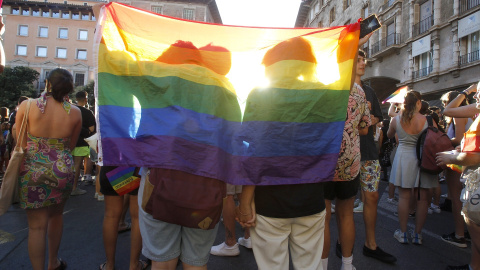 Una pareja tapada con una bandera LGTB en una imagen de archivo.
