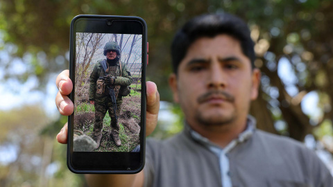ACOMPAÑA CRÓNICA: PERÚ UCRANIA GUERRAAME963. LIMA (PERÚ), 21/08/2026.- A., hijo de uno de los cientos de peruanos reclutados por Rusia para luchar contra Ucrania y de quien su familia no tiene noticias desde hace 100 días, muestra en un teléfono la fotografía de su padre durante una entrevista con EFE este miércoles, en Lima (Perú). "Mi papá (60 años) viajó el 19 de marzo a Rusia con ofertas laborales de que iba a trabajar como vigilante. Le habían dicho que iba a hacer una labor en zonas tranquilas, cuidando torreones, bases militares, pero cuando llegó allá la situación era muy distinta", relata a EFE A., que prefiere no identificarse por motivos de seguridad. EFE/Paolo Aguilar