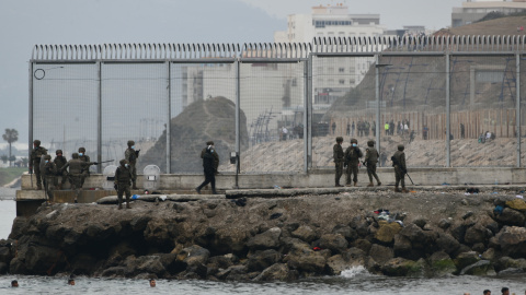 Varios militares del ejército español vigilan durante las devoluciones en caliente que efectuaron a las personas migrantes en Ceuta, a 18 de mayo de 2021. Varios militares del ejército español vigilan durante las devoluciones en caliente que efectuaron a las personas migrantes en Ceuta, a 18 de mayo de 2021.