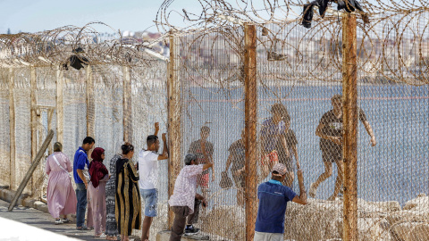 Ciudadanos marroquíes en la frontera mientras unos jóvenes migrantes regresan el 2 de agosto de 2026.