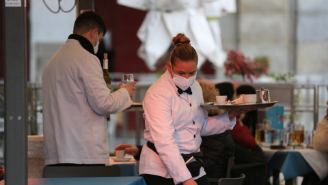 Dos camareros trabajan en la terraza de un bar en el centro de Madrid (España).