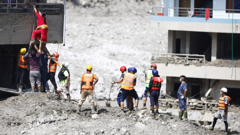 Voluntarios ayudan a rescatar a una persona atrapada en un edificio afectado por la riada, a 27 de agosto de 2026. Voluntarios ayudan a rescatar a una persona atrapada en un edificio afectado por la riada, a 27 de agosto de 2026.