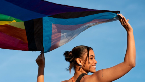 Una persona sujeta una bandera del colectivo LGTBIQA+. Una persona sujeta una bandera del colectivo LGTBIQA+.