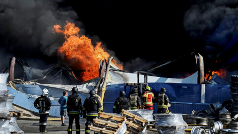 Bomberos haciendo labores de extinción tras el ataque ruso cerca de Kiev.