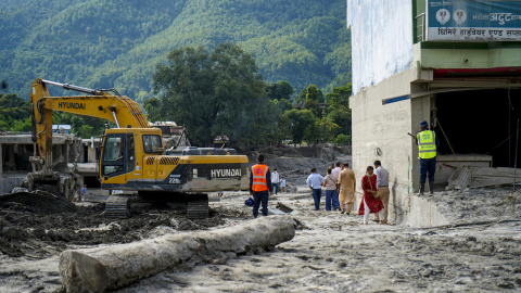 Excavadora y efectivos nepalíes trabajando en labores de rescate en Devighat (Nepal).
