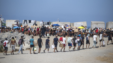 Decenas de migrantes caminan por la playa del Trampolín, a 31 de agosto de 2026, en Ceuta. Decenas de migrantes caminan por la playa del Trampolín, a 31 de agosto de 2026, en Ceuta.