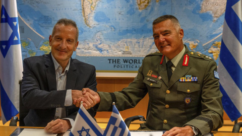 El director general del Ministerio de Defensa de Israel (IMOD), el general de división Amir Baram (izq) y su homólogo griego, Ioannis Bouras (dcha), se dan la mano al firmar el acuerdo de exportación de armamento, Escudo de Aquiles, en Israel (31.08.26)