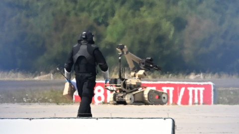 Un técnico forense trabaja junto a un robot de desactivación de explosivos cerca de un avión ucraniano en el aeropuerto de Leipzig.