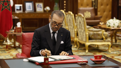 El rey de Marruecos, Mohamed VI, firma unos documentos en el Palacio Real de Rabat.