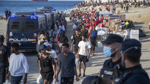 Miembros de la Cruz Roja atienden a varios migrantes, en la playa del Trampolín, en Ceuta. Miembros de la Cruz Roja atienden a varios migrantes, en la playa del Trampolín, en Ceuta.