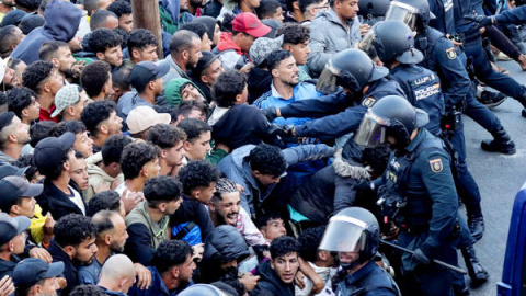 Policías cargan contra varias personas durante el traslado de migrantes en Ceuta.