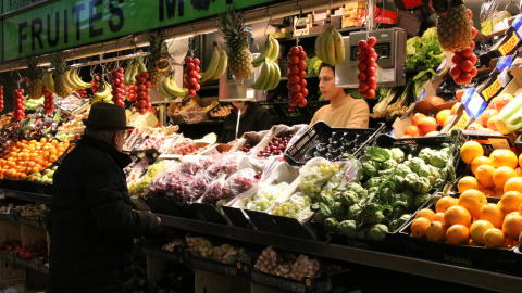 Una persona comprant fruita al mercat del Lleó Una persona comprant fruita al mercat del Lleó
