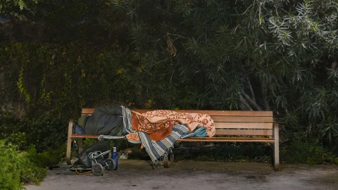 Una persona dormint en un banc a Barcelona (dijous 04 de desembre del 2025) Una persona dormint en un banc a Barcelona