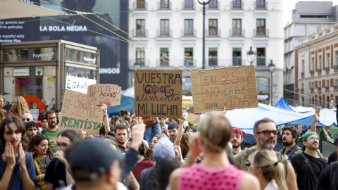 Varias personas protestan en la Puerta del Sol donde unas mil personas llevan acampadas ya tres noches por la situación de la vivienda.
