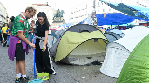 Dos campistas por la vivienda barren la Puerta del Sol.