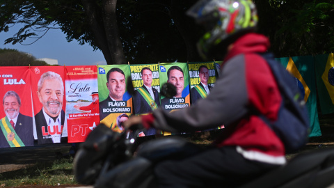 Una persona conduce su motocicleta frente a carteles de las elecciones brasileñas de este 4 de octubre de 2026.