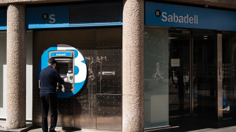 Un hombre opera en un cajero del Banco de Sabadell en Madrid, en una imagen de archivo. Un hombre opera en un cajero del Banco de Sabadell en Madrid, en una imagen de archivo.