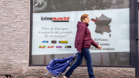 Imagen de archivo de una mujer caminando hacia un supermercado en París. Imagen de archivo de una mujer caminando hacia un supermercado en París.