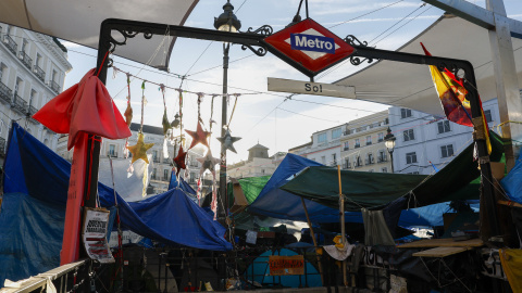 Una de las bocas del Metro de la estación de la Puerta del Sol entre las tiendas de la acampada por la vivienda.