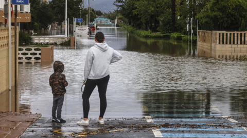 Una mujer y un niño observan una zona inundada, a 19 de octubre de 2026, en Guardamar de la Safor, València.