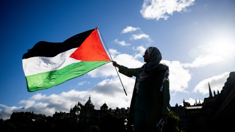 Imagen de archivo de una mujer alzando la bandera de Palestina. Imagen de archivo de una mujer alzando la bandera de Palestina.