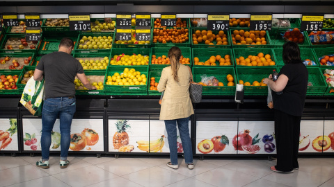 Varias personas realizan la compra en un supermercado. Varias personas realizan la compra en un supermercado.