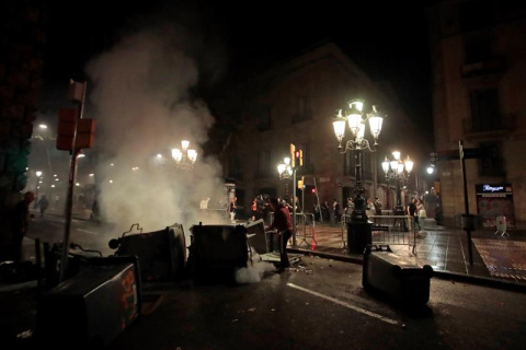 Un vecino apaga un contenedor ardiendo en las Ramblas de Barcelona. EFE/Marta Pérez