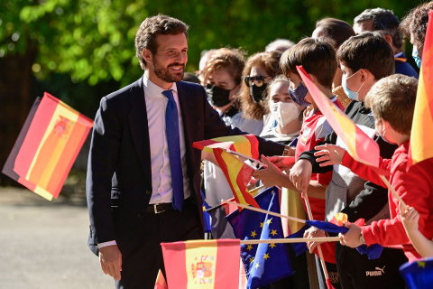 El líder conservador del Partido Popular (PP) español, Pablo Casado, saluda a los niños que ondean banderas europeas y españolas cuando llega a la ceremonia del Premio Europeo Carlos V en el Real Monasterio de Yuste, en Cuacos de Yuste, el 14 de octub