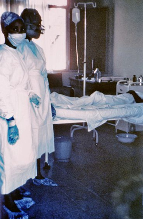 Fotografía de 1976, con dos enfermeras de pie junto a un paciente infectado por el virus del Ébola, que murió pocos días después debido a graves hemorragias internas. CDC, CC BY Fotografía de 1976, con dos enfermeras de pie junto a un paciente infectado por el virus del Ébola, que murió pocos días después debido a graves hemorragias internas. CDC, CC BY
