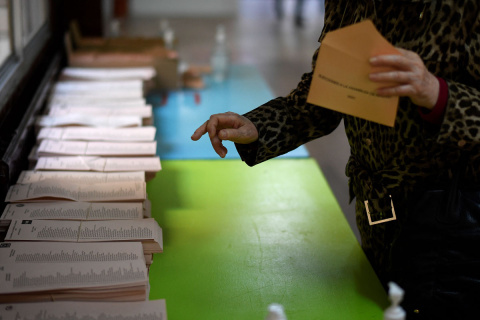  Una mujer recoge una papeleta en un colegio electoral en Madrid durante las elecciones regionales de Madrid el 4 de mayo de 2021.- AFP