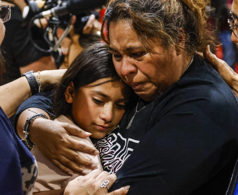  Una mujer llora mientras abraza a una niña, durante una reunión de la comunidad en el recinto ferial del condado de Uvadle, tras un tiroteo masivo en la escuela primaria Robb en Uvalde, Texas, Estados Unidos, este jueves.- EFE