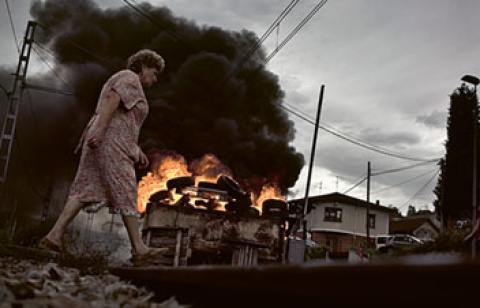 Una mujer pasa por delante de una barricada que corta las vías en Pola de Laviana, cuencas mineras, Asturias, 2012.- JOSÉ COLÓN Una mujer pasa por delante de una barricada que corta las vías en Pola de Laviana, cuencas mineras, Asturias, 2012.- JOSÉ COLÓN
