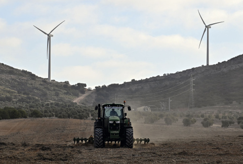 Fotografía: Un tractor labra un campo frente a los aerogeneradores del parque eólico Romeral de Toledo, 2023.- ÓSCAR DEL POZO VIA AFP. Fotografía: Un tractor labra un campo frente a los aerogeneradores del parque eólico Romeral de Toledo, 2023.- ÓSCAR DEL POZO VIA AFP.